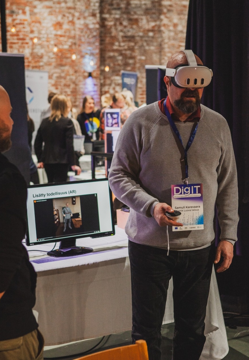 Samuli Karevaara esittelee VR-lasit päässään ständillä lisätyn todellisuuden esitystä
